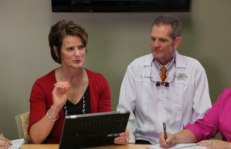 kristy crabtree directing a staff meeting while sitting next to dr crabtree at crabtree dental office in katy texas