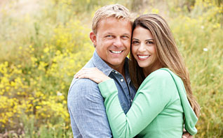 a young couple hugging with bushes in the background after an extraordinary visit to crabtree dental in katy texas